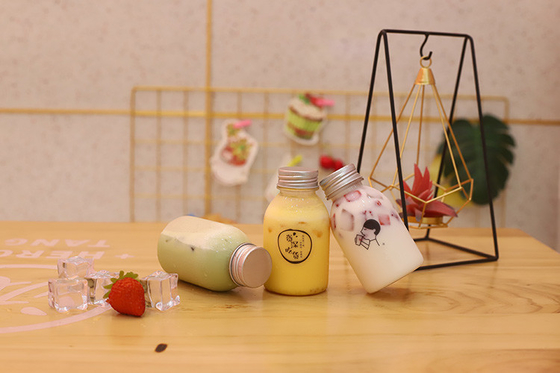 Bottiglie di tè di latte di plastica con maniglia per bere con materiale ed efficienza